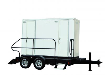 Professional multi-stall luxury restroom trailer with dual-axle stability, integrated stairs, and safety railings for high-end events.