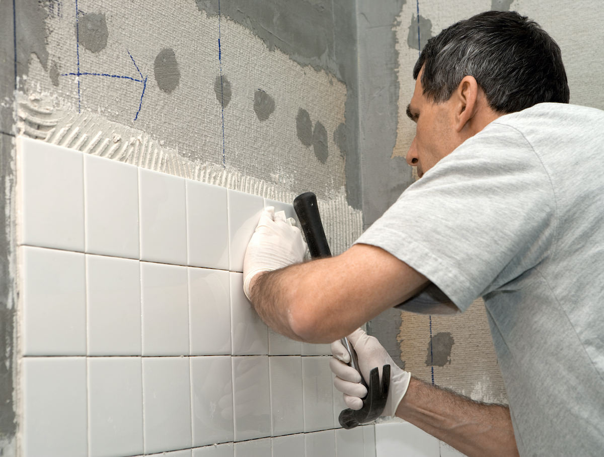 Man laying tile for home improvement project