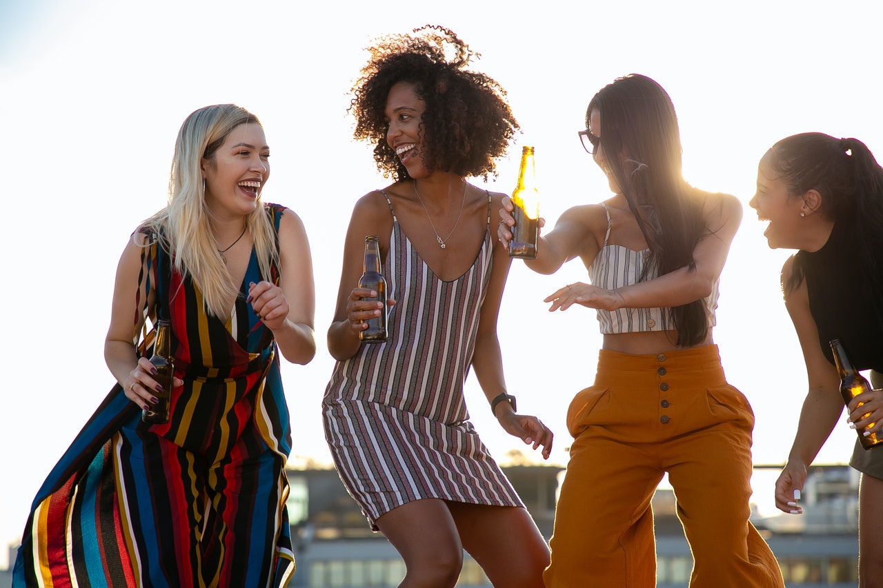 image of women dancing outside | portable toilets for outdoor events