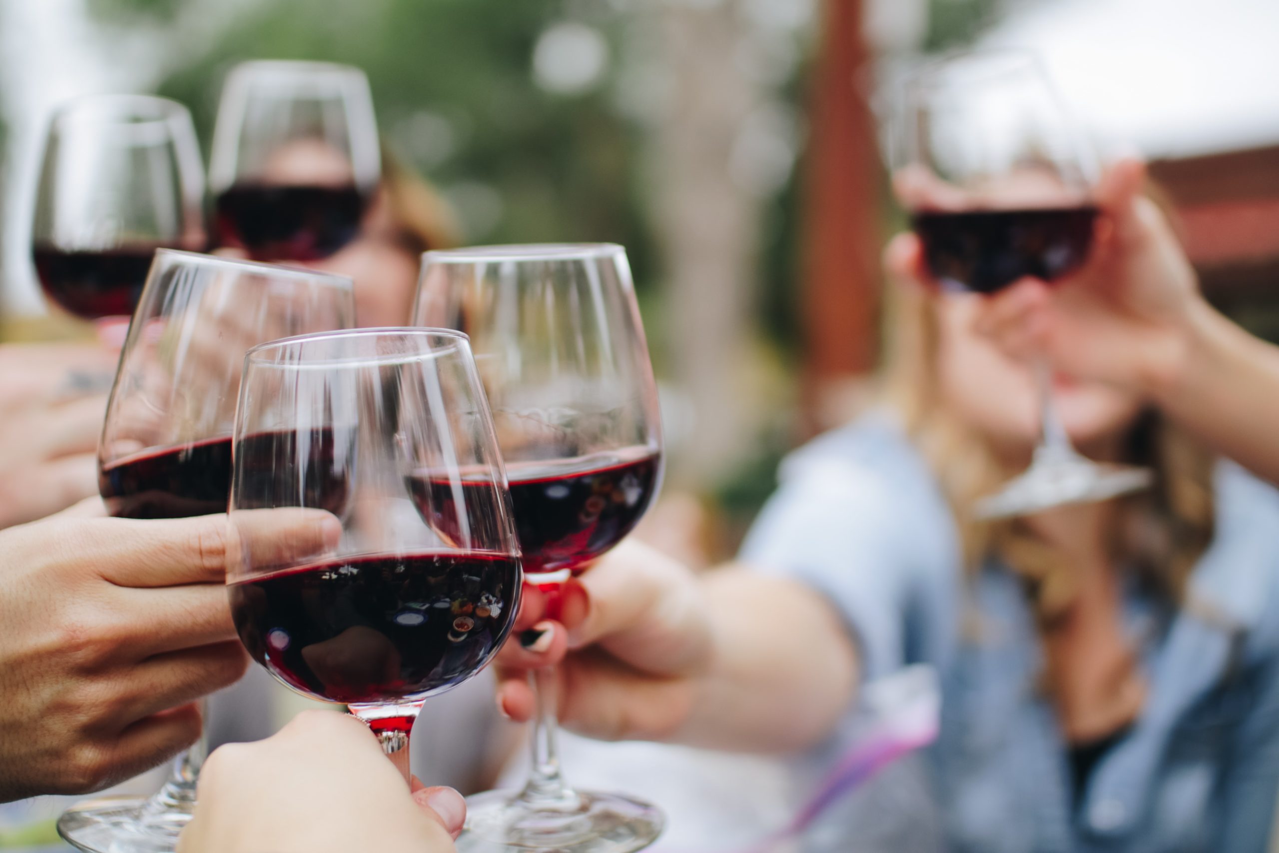 people toasting with glasses of red wine | portable restrooms vancouver