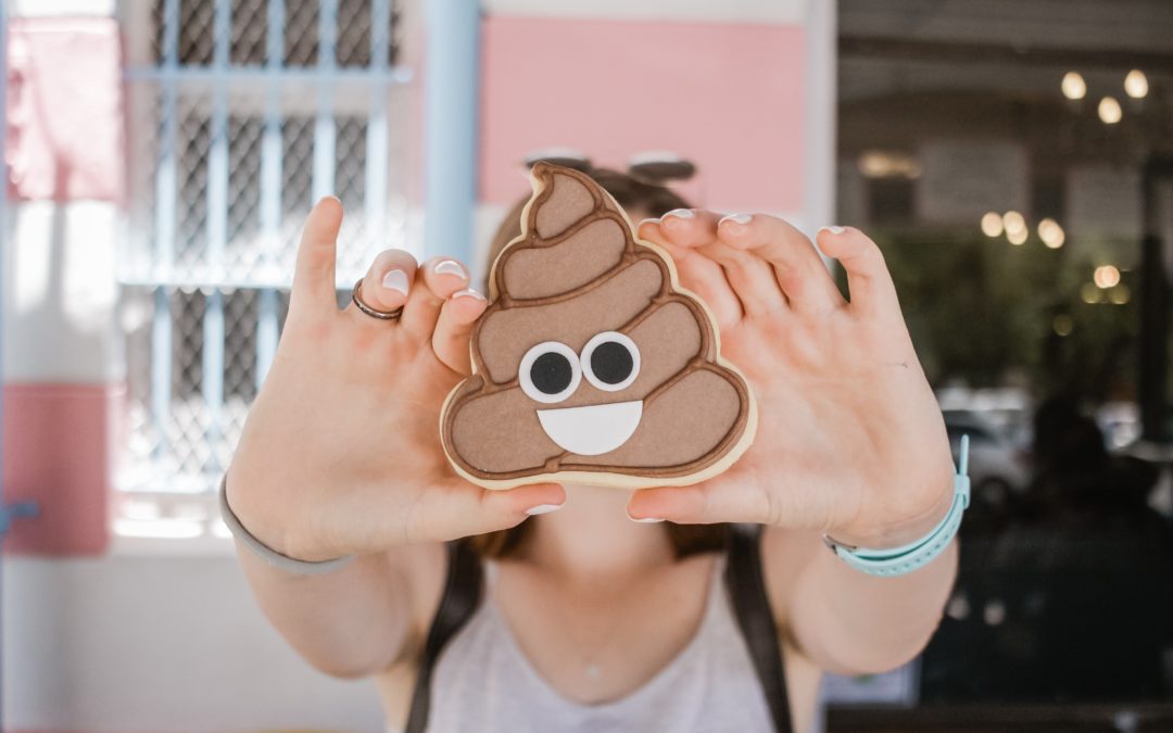 image of person holding sticker with poop emoji | porta potty rental vancouver salem portland oregon washington